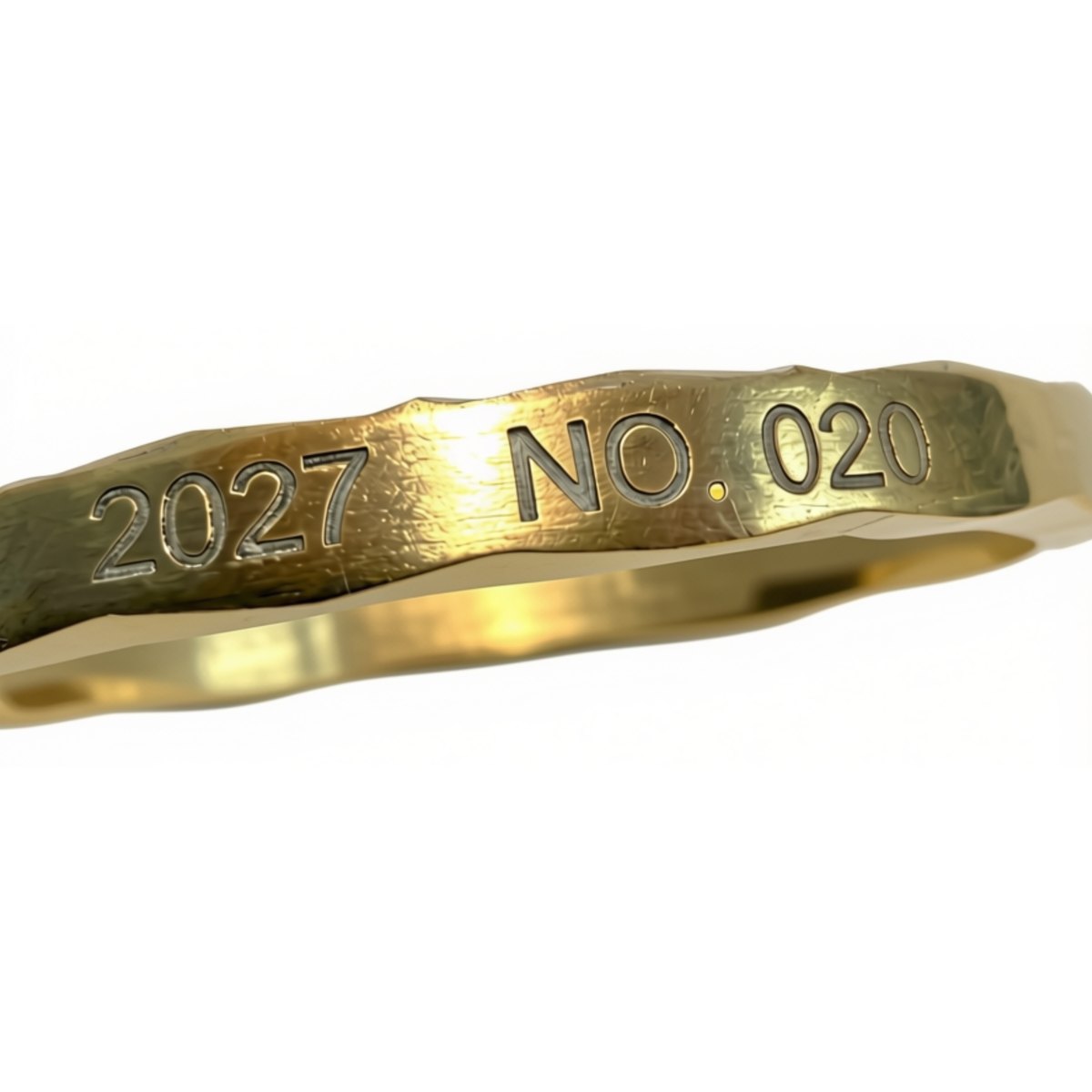 Nærbilde av myntens diamantslipte kant med lasergravert løpenummer 2027 · NO. 020